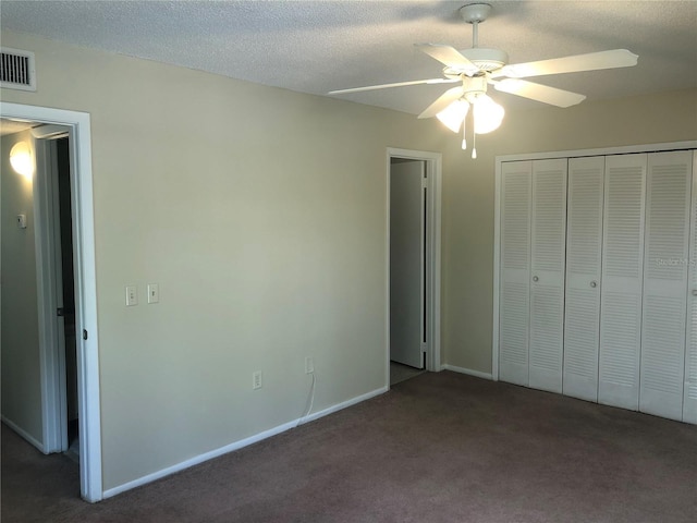 unfurnished bedroom with a closet, a textured ceiling, visible vents, and carpet flooring