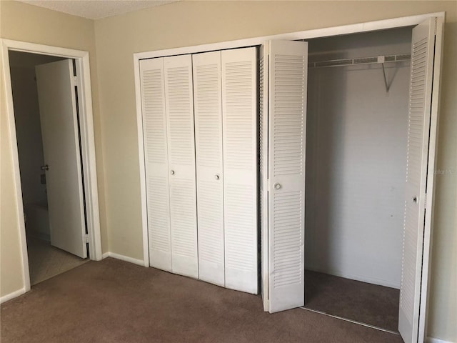 unfurnished bedroom with a closet and carpet flooring