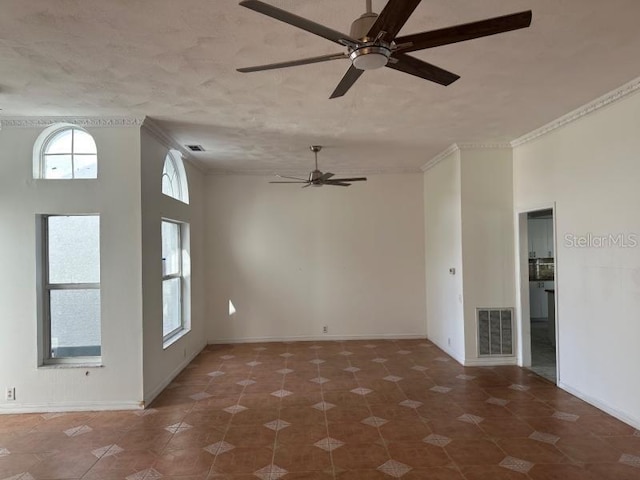 spare room featuring baseboards, visible vents, and crown molding