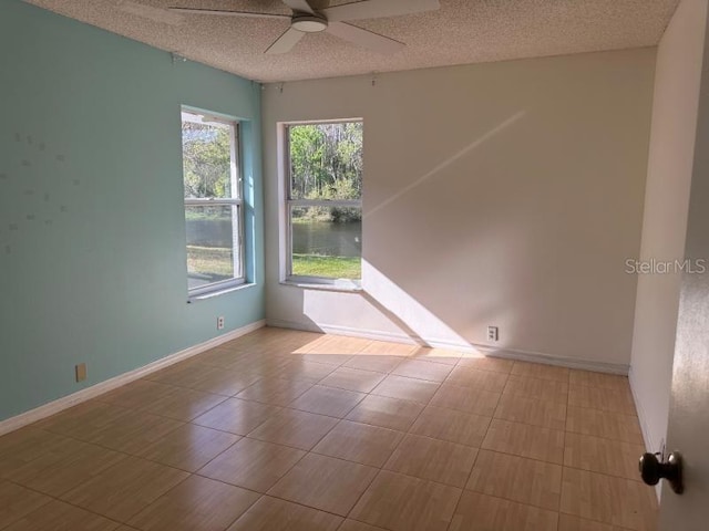 unfurnished room with ceiling fan, baseboards, and a textured ceiling