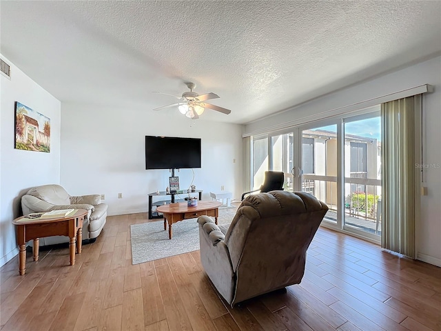 562 Orange Dr Unit 33, Altamonte Springs, FL 32701 - living room with light wood finished floors, visible vents, baseboards, a textured ceiling, and a ceiling fan