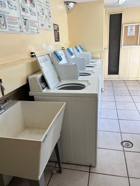 562 Orange Dr Unit 33, Altamonte Springs, FL 32701 - common laundry area featuring light tile patterned floors, a sink, and washing machine and clothes dryer