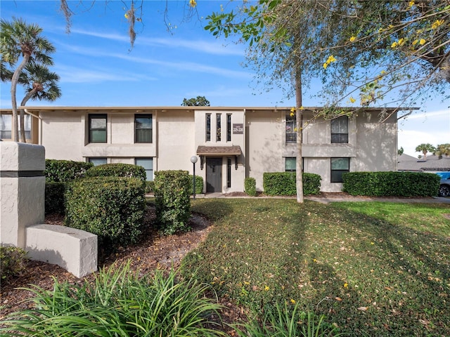 view of front of property featuring a front lawn and stucco siding