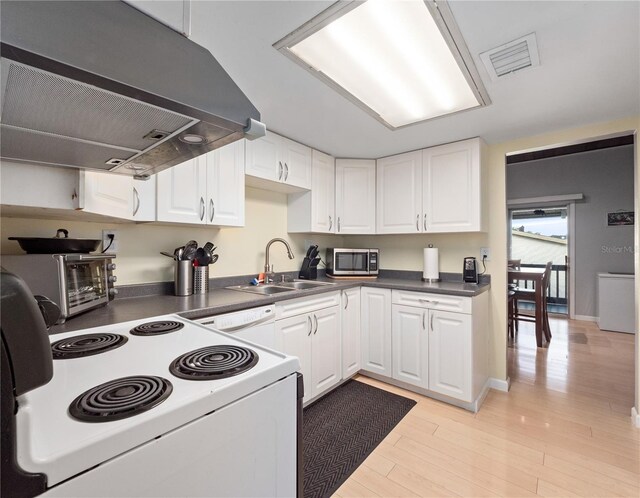 kitchen featuring under cabinet range hood, white appliances, a sink, visible vents, and white cabinets