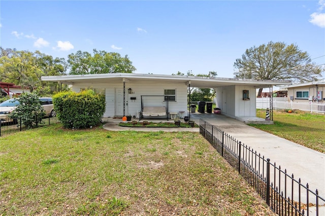 view of front facade featuring concrete driveway, an attached carport, a front lawn, and fence