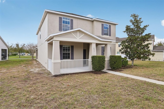 view of front of home with a porch, a front lawn, and stucco siding