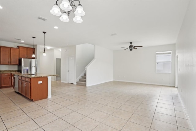 1893 Rafton Rd, Apopka, FL 32703 - kitchen with light tile patterned flooring, visible vents, appliances with stainless steel finishes, brown cabinets, and decorative light fixtures