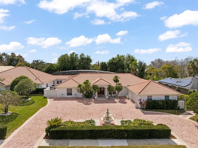 view of front facade featuring driveway, a front yard, fence, and a tiled roof