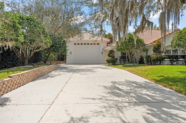 mediterranean / spanish house featuring driveway, a garage, a tile roof, a front yard, and stucco siding