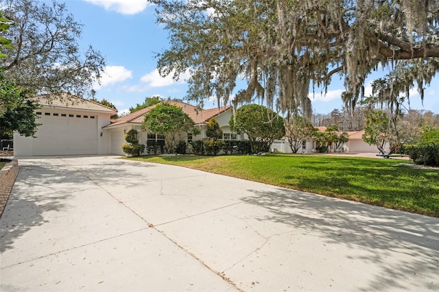 view of front of home with a garage, concrete driveway, a front lawn, and stucco siding