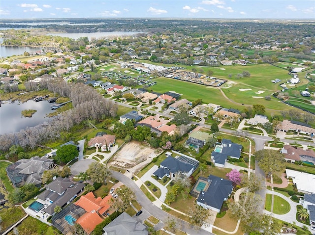 aerial view featuring golf course view, a water view, and a residential view