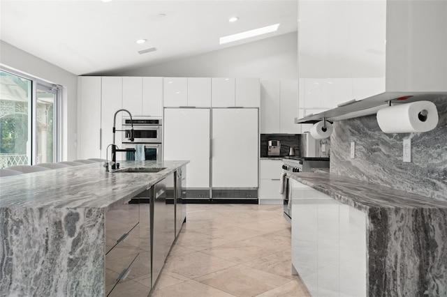 kitchen featuring stainless steel appliances, white cabinetry, a sink, and modern cabinets