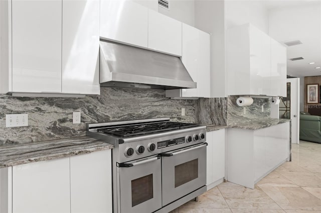 kitchen with visible vents, white cabinetry, double oven range, decorative backsplash, and wall chimney exhaust hood