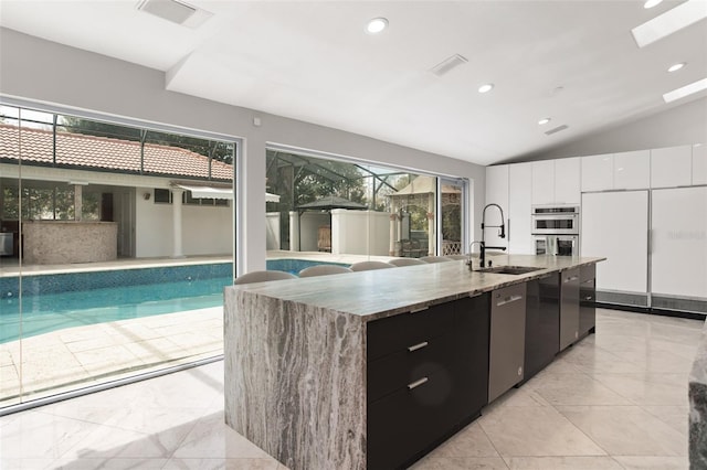 kitchen featuring stainless steel appliances, modern cabinets, a sink, and a wealth of natural light