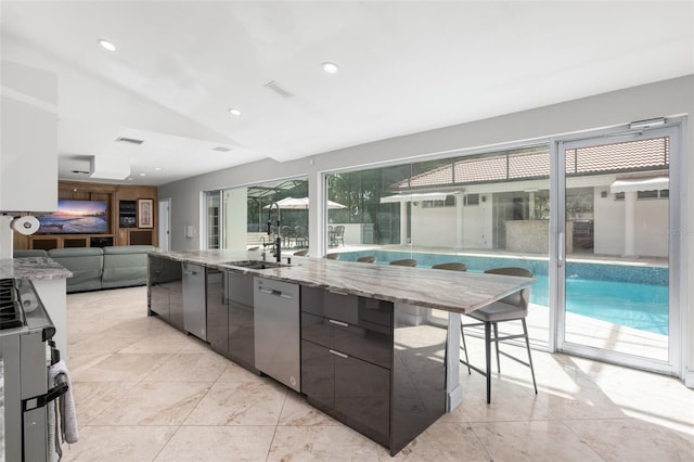 kitchen with light stone countertops, dishwasher, a large island, and modern cabinets