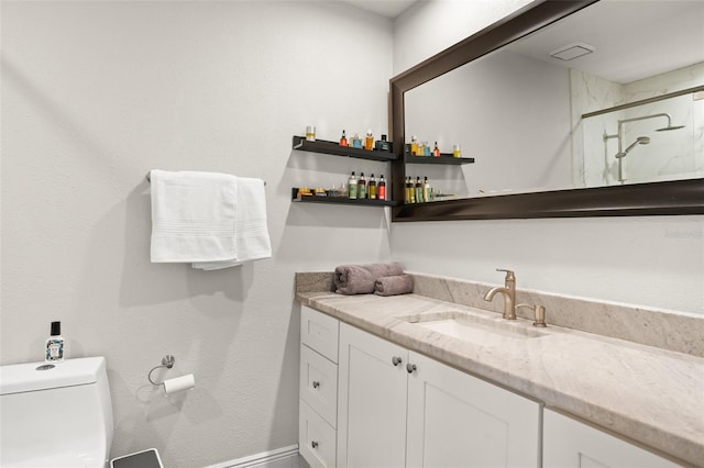 bathroom featuring vanity, a marble finish shower, toilet, and baseboards