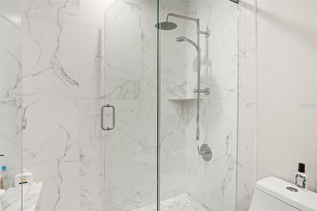 full bath featuring a textured wall, a marble finish shower, and toilet