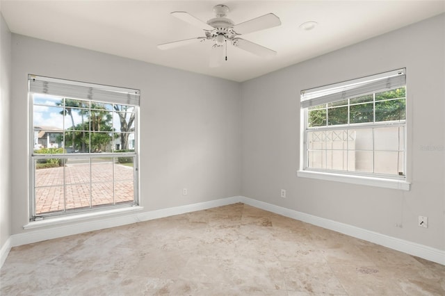 unfurnished room with ceiling fan and baseboards