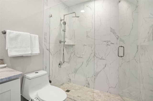 bathroom featuring toilet, a marble finish shower, and vanity