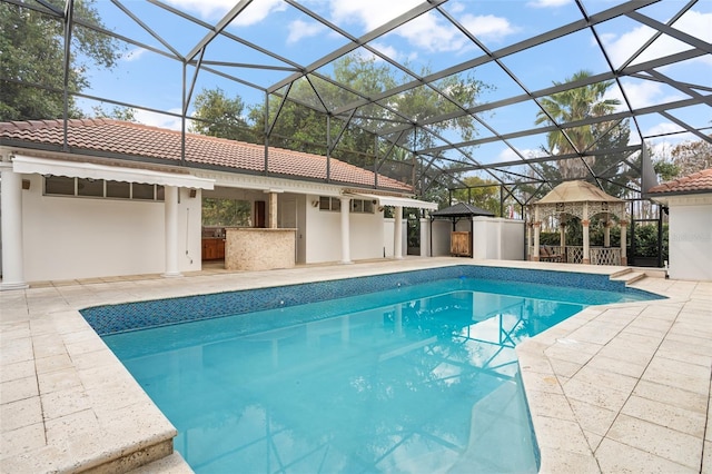 pool with glass enclosure, outdoor dry bar, area for grilling, and a patio