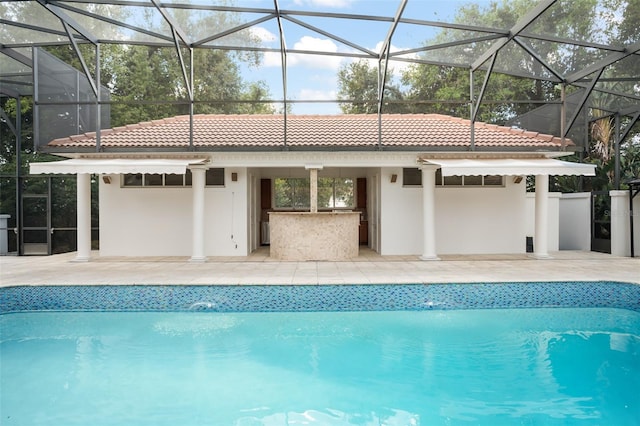 rear view of house with an outdoor pool, a patio, a tile roof, outdoor dry bar, and stucco siding