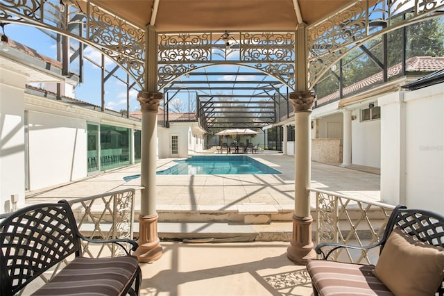 pool featuring glass enclosure and a patio