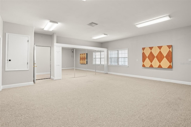 spare room with visible vents, light carpet, and baseboards