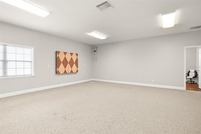 carpeted empty room with visible vents and baseboards