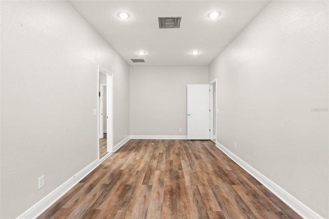 unfurnished room with baseboards, visible vents, and wood finished floors