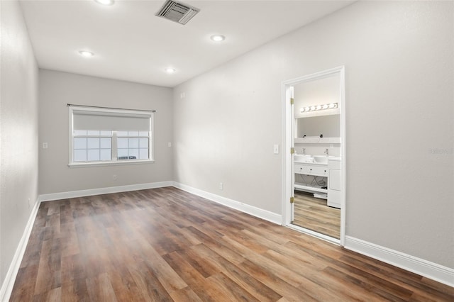 unfurnished room featuring baseboards, visible vents, wood finished floors, and recessed lighting