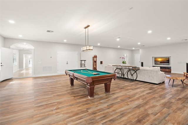 game room with light wood-style floors, arched walkways, and recessed lighting