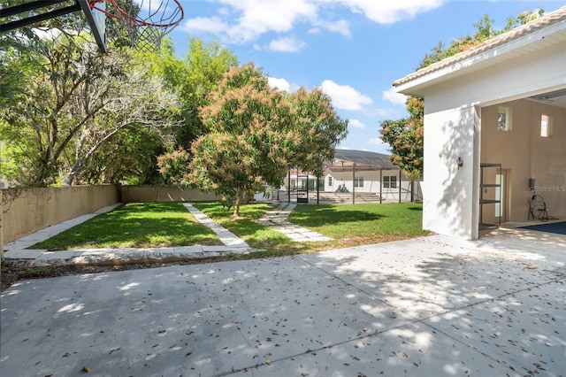 view of yard with a patio area, a fenced backyard, and a lanai