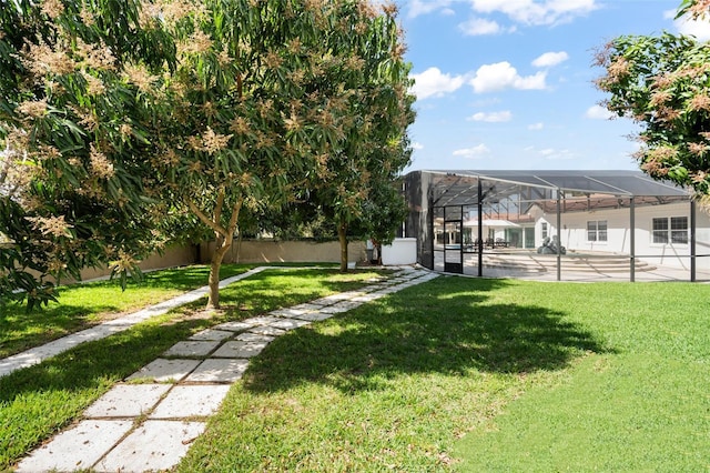 view of yard featuring fence private yard, glass enclosure, and a patio