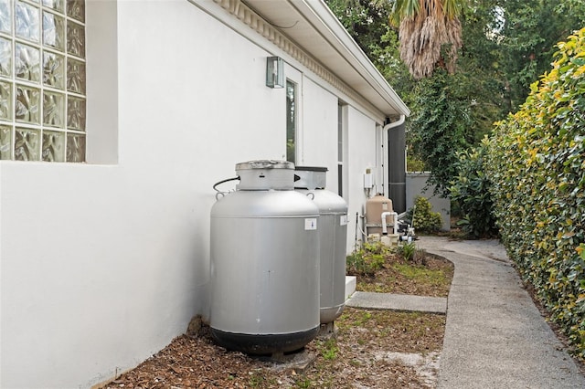 exterior details with heating fuel, fence, and stucco siding