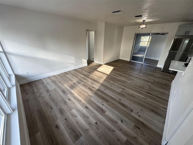 interior space featuring baseboards, visible vents, and dark wood finished floors