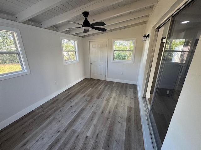 unfurnished bedroom with vaulted ceiling with beams, multiple windows, baseboards, and wood finished floors