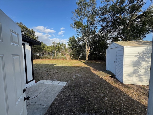 view of yard with a storage shed, fence, and an outdoor structure