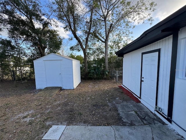 view of yard with an outdoor structure, a storage shed, and fence