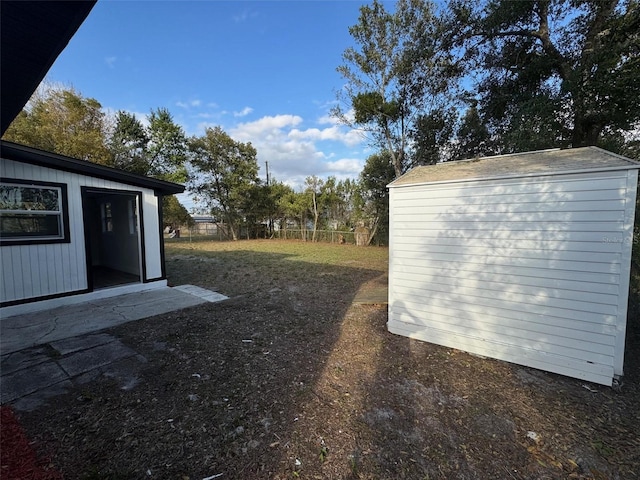 view of yard featuring fence and an outbuilding