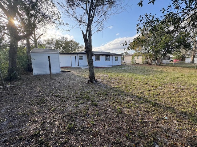 view of yard featuring an outdoor structure, a shed, and fence