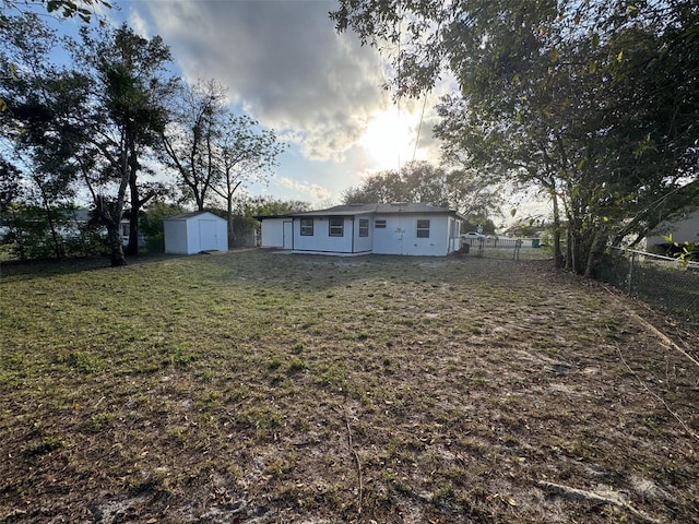 exterior space featuring a shed, fence, and an outbuilding