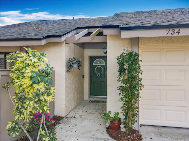 property entrance with a shingled roof and stucco siding