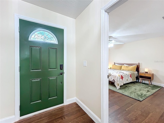 entryway with dark wood-style floors, ceiling fan, baseboards, and a textured ceiling