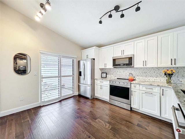 kitchen featuring dark wood finished floors, stainless steel appliances, lofted ceiling, tasteful backsplash, and white cabinetry