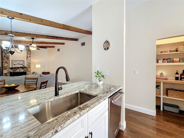 kitchen with white cabinets, light stone counters, dark wood-type flooring, a sink, and stainless steel dishwasher