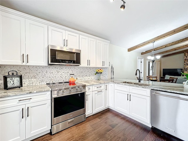 kitchen with dark wood finished floors, tasteful backsplash, appliances with stainless steel finishes, white cabinetry, and a sink