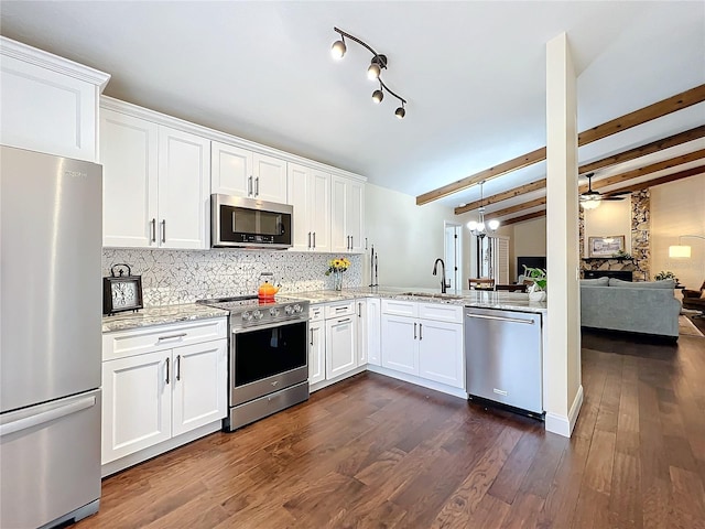 kitchen featuring tasteful backsplash, appliances with stainless steel finishes, light stone counters, and dark wood-style flooring