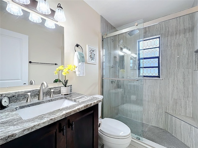 full bath with a stall shower, vanity, and toilet