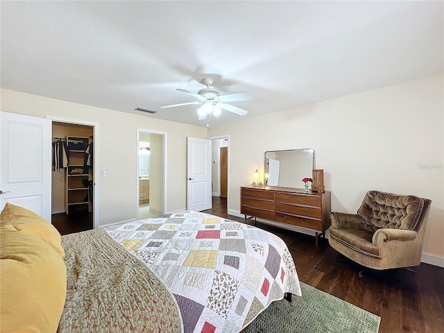 bedroom featuring wood finished floors, visible vents, baseboards, a closet, and a walk in closet