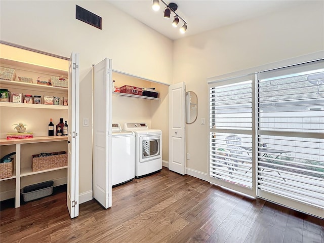 clothes washing area with laundry area, baseboards, visible vents, dark wood-style floors, and washing machine and clothes dryer